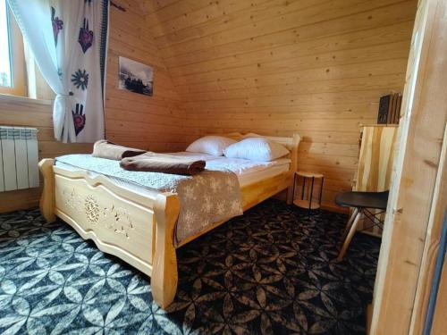 a bedroom with a bed in a wooden room at Kunatówka domek w Zębie in Ząb