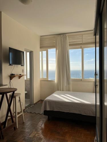 a bedroom with a bed and a large window at Melhor Localização do Centro Histórico de Salvador in Salvador