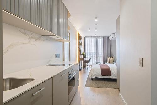 a kitchen with a sink and a bed in a room at 5 Star Elegant Apartments, Ellipse, Waterfall City, Midrand, Johannesburg in Midrand