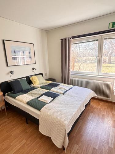 a bedroom with a large bed in front of a window at B&B Villa Vila in Löttorp