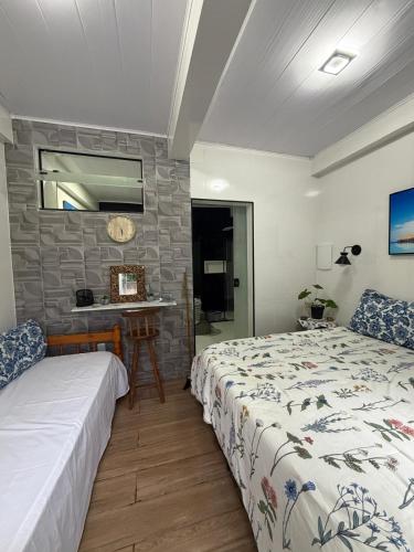 a bedroom with two beds and a stone wall at vista mar suite luxo in Angra dos Reis