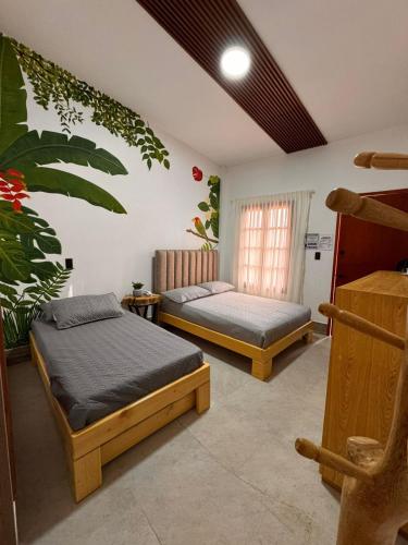 a bedroom with two beds and a window at Hotel Campestre Alma Nativa in Calarcá