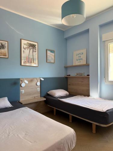 two beds in a room with blue walls at Costa blancavibes, Solo Familias in Playa de Gandia
