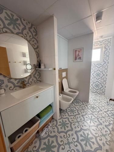 a bathroom with a toilet and a sink and a mirror at Costa blancavibes, Solo Familias in Playa de Gandia