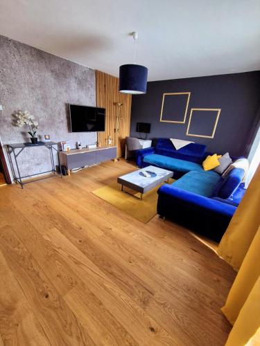 a living room with a blue couch and a tv at Stan na dan Koprivnica-Comfort in Koprivnica