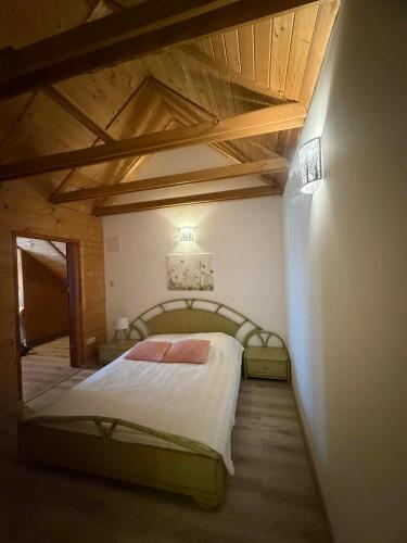 a bedroom with a large bed with a wooden ceiling at Karczma Biesiadna in Dalnia