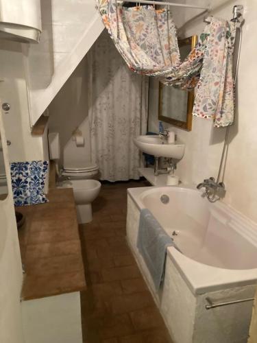 a bathroom with a sink and a tub and a toilet at Casa Odara suite centro storico in Calcata