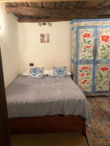 a bedroom with a bed with blue and white pillows at Casa Odara suite centro storico in Calcata