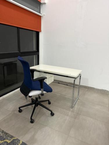 a desk and a blue chair in a room at Departamento Torre Onze in Mérida