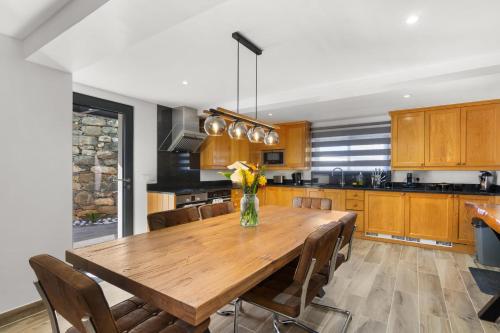 a kitchen with a wooden table and chairs at The Green Valley Porto Moniz in Achadas da Cruz