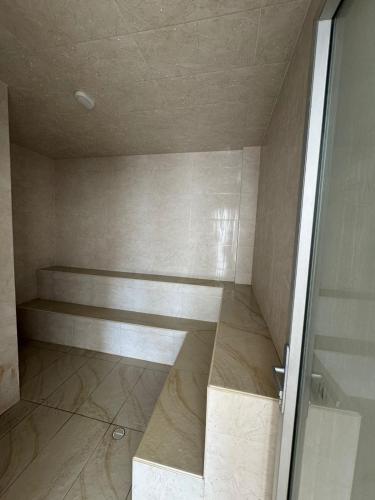 a room with a shower with a bench and a door at San gil plaza confort in San Gil