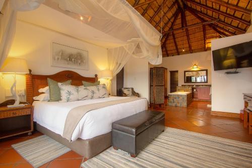 a bedroom with a large bed in a room at Kruger Private Lodge in Marloth Park