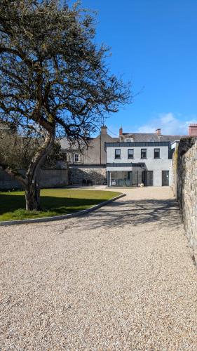 a large white building with a tree in front of it at Trim private rooms in Trim