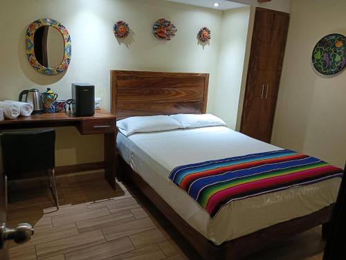 a bedroom with a bed with a desk and a mirror at hotel rio mar in Puerto Vallarta