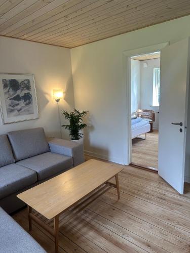 ein Wohnzimmer mit Sofa und Tisch in der Unterkunft Dejrupvej in Ovtrup