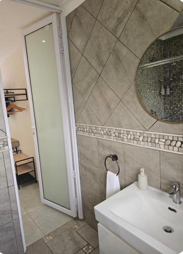 a bathroom with a sink and a mirror at Grey heron in Boksburg