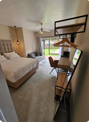 a bedroom with a bed and a desk with a chair at Grey heron in Boksburg
