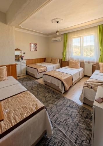 a hotel room with three beds and a rug at Aspawa Hotel in Pamukkale