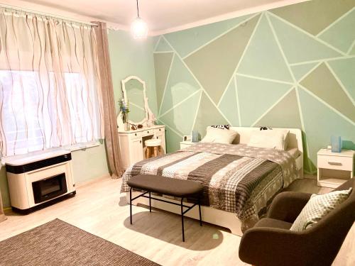 a bedroom with a bed and a chair in it at Lelle-kert Apartman 02 in Balatonlelle