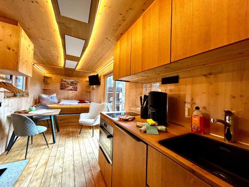 a kitchen with wooden cabinets and a living room at Vollholz-Ferienhaus Herbert's Alte Gärtnerei im Naturpark Zittauer Gebirge in Hainewalde