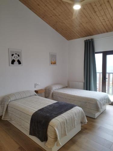 a bedroom with two beds and a window at Vistas a Cangas in Cangas de Onís