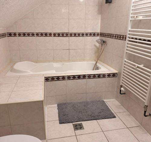 a white bath tub in a bathroom with a rug at daroomz in Gloggnitz