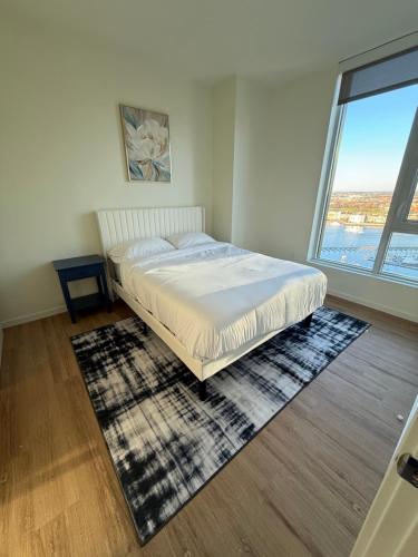 a bedroom with a bed and a large window at Luxe Apartment with Harbor views in Baltimore