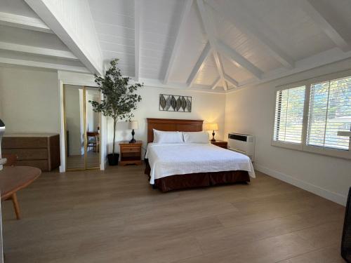 a bedroom with a white bed and a large window at Carmel Resort Inn in Carmel