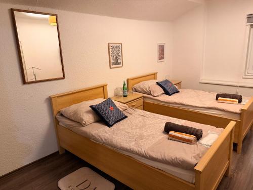 two beds in a room with a mirror at daroomz in Gloggnitz