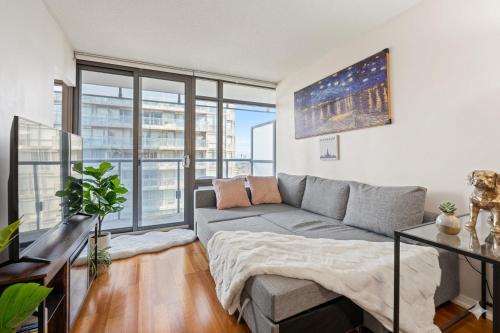 a living room with a couch and a large window at Stylish 2BR Downtown Sanctuary - Free Parking in Toronto