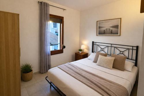 a bedroom with a bed and a window at Blue House Calafell in Calafell
