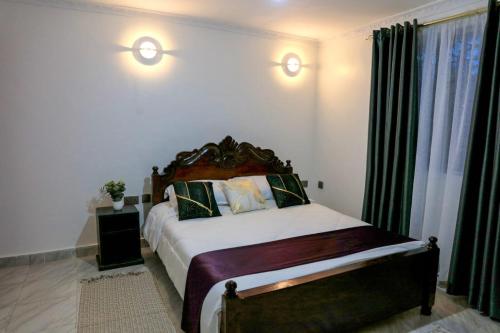 a bedroom with a bed with a wooden headboard at Asili House in Sagana