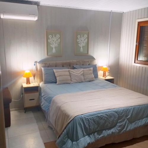 a bedroom with a bed and two lamps on tables at Casa de verão vó judite -praia Sulmar- 4 quartos in Balneário Gaivotas