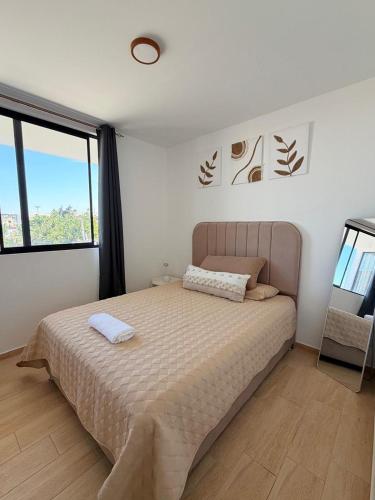 a bedroom with a bed and a large window at Dpto familiar moderno 2do piso - 2 Hab - 3 camas - wifi - lavadora in Tacna