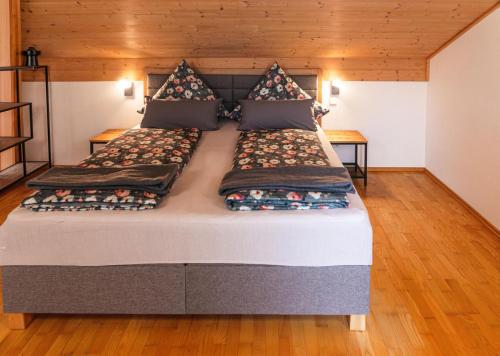 a large bed in a room with wooden floors at Landhausvilla Watzmannblick in Saaldorf-Surheim