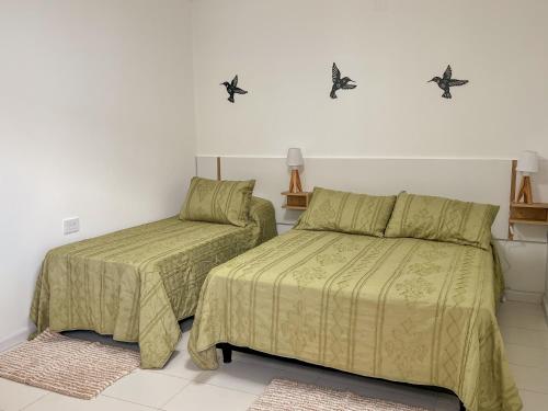 a bedroom with two beds and two rugs at Hotel Parador El Tucán in Parana