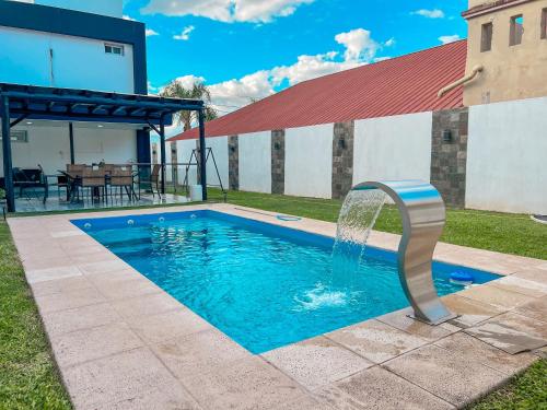 a swimming pool with a fountain in a yard at Hotel Parador El Tucán in Parana