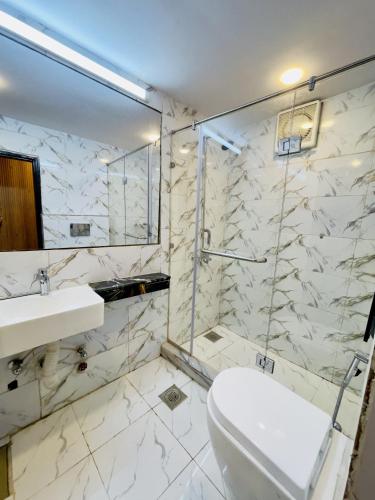a bathroom with a shower and a toilet and a sink at Hotel Five Rivers - 2 Min to Allama Iqbal International Airport, Lahore in Lahore