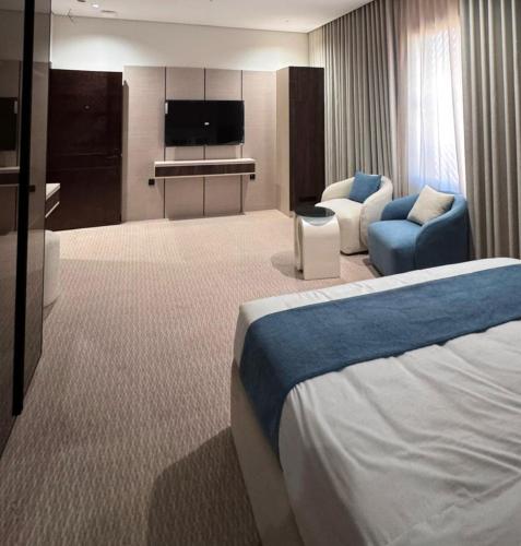 ein Hotelzimmer mit Bett und Wohnzimmer in der Unterkunft Highest End Hotel in Al-'Ula