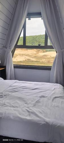 a bed in a room with a window at Dunas beach club in Jaguaruna