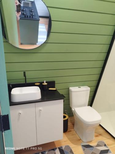 a bathroom with a white toilet and a mirror at Dunas beach club in Jaguaruna