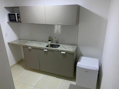 a small kitchen with a sink and a toilet at Flat Manaira in João Pessoa