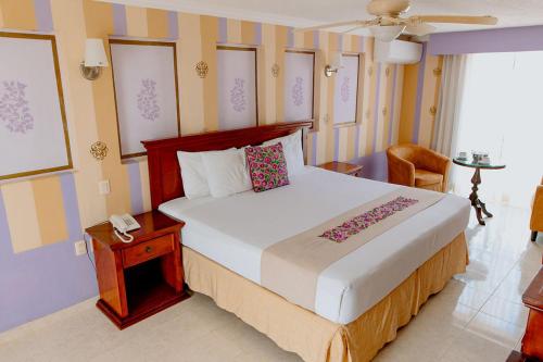 a bedroom with a large bed and a phone at Hotel Plaza Colonial in Campeche