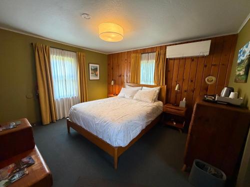 a bedroom with a large bed and two windows at Priest Station Cafe & Cabins in Groveland