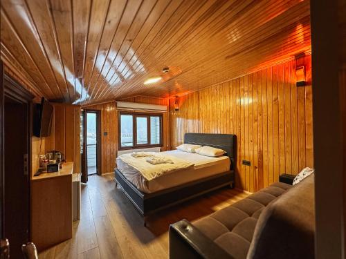 a bedroom with a bed and a couch in a room at Doga Motel in Uzungöl