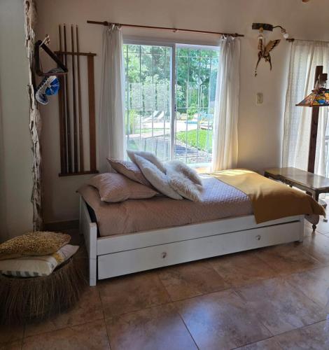 a bedroom with a bed with a large window at Los robles in San Pedro