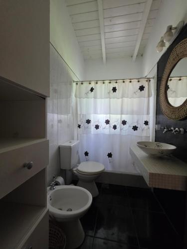 a bathroom with a toilet and a sink and a shower curtain at Los robles in San Pedro