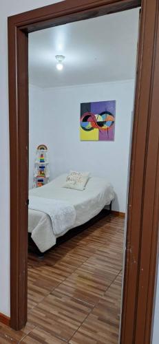 a bedroom with a bed and a painting on the wall at Casa Azul in Coñaripe