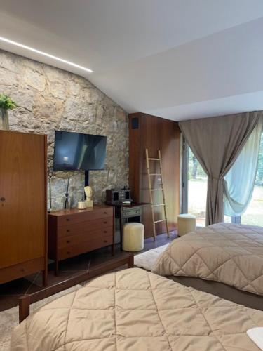a bedroom with a bed and a flat screen tv at Quinta dos Amores in Ponte de Lima