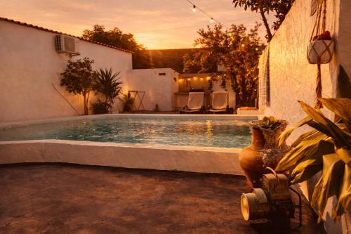 a swimming pool with a vase next to a building at Refúgio do Frade in Aldeia do Mato
